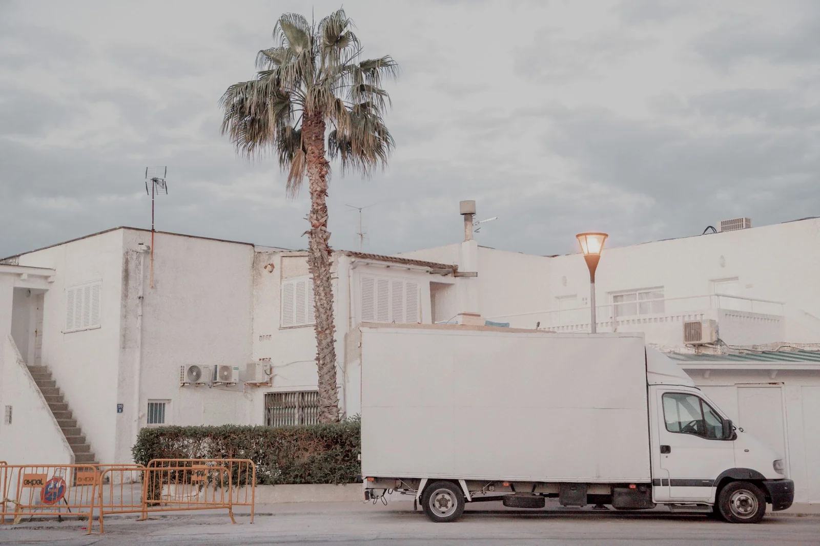 Camion de déménagement devant un immeuble de pierre claire dans une rue de Caen