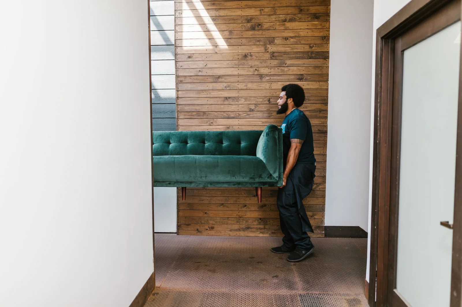 Équipe de déménageurs portant un canapé dans un escalier d'immeuble